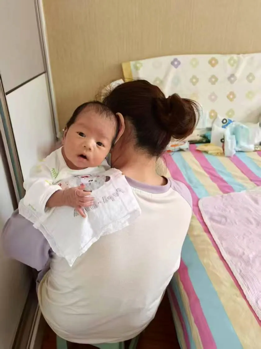 刘向华竖抱婴儿进行拍嗝和安抚